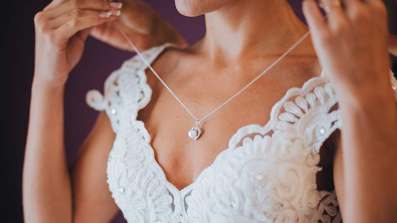 Bride puts on necklace