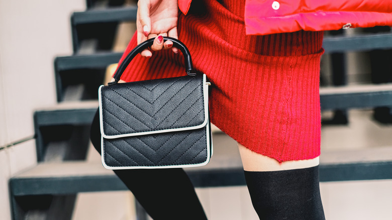 A woman carrying a small handbag as an accessory