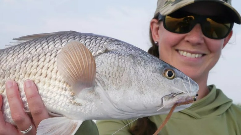 Woman holding large silver fish