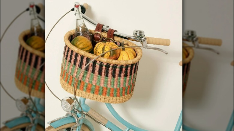 Colorful woven bike basket filled with gourds