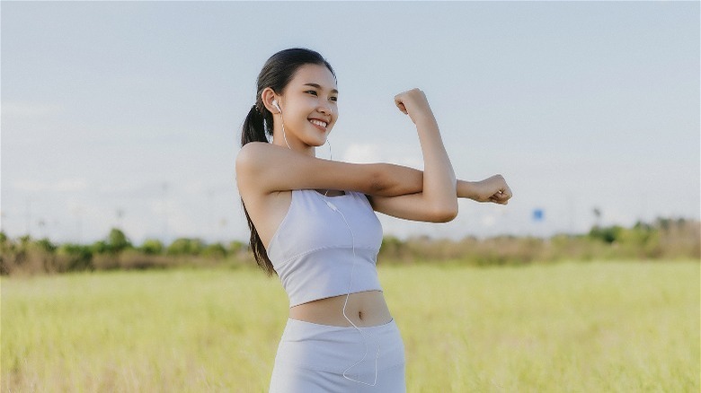 Smiling woman stretching after workout