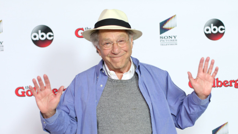 George Segal wearing a hat and smiling