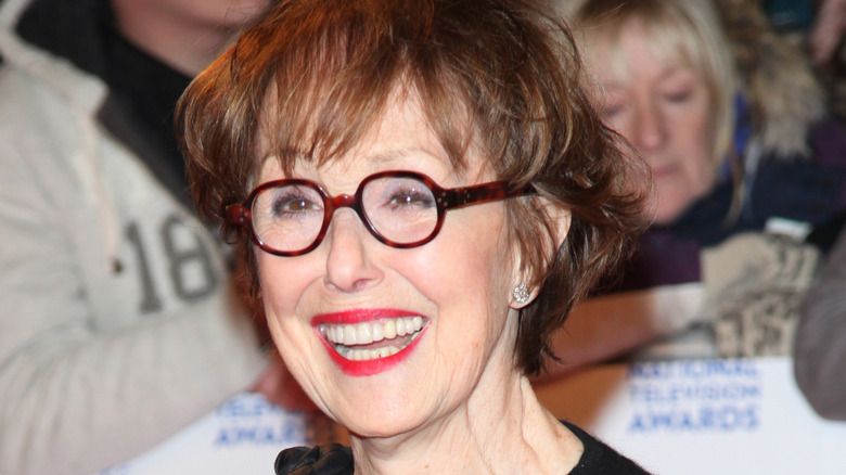 Una Stubbs wearing glasses