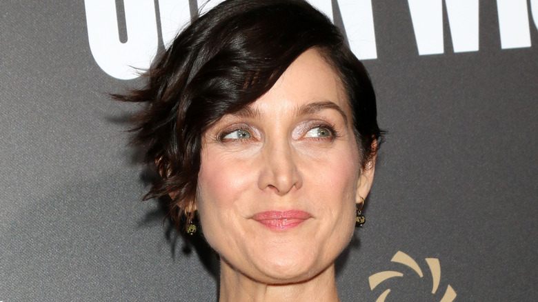 Carrie-Anne Moss smirking