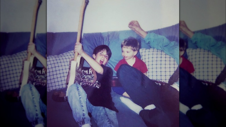 A young Adam Levine holding guitar