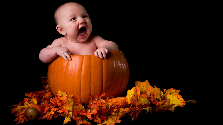 Laughing baby in pumpkin