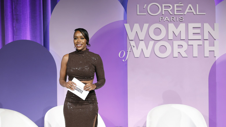 Aja Naomi King holds a card on stage