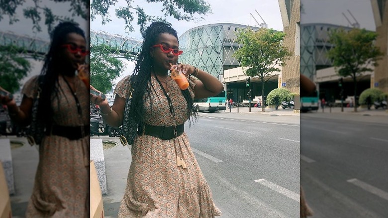 Leila Roker sipping a beverage outside