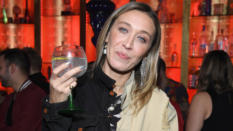 Alana Hadid posing with a cocktail