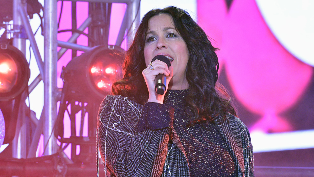 Alanis Morissette performing in plaid jacket with hair down