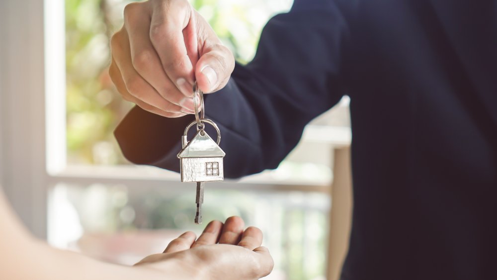 Realtor giving key to property buyer