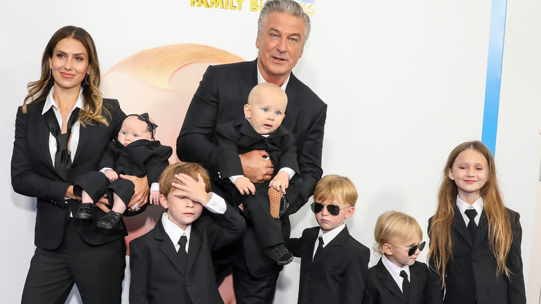 Alec Baldwin and Hilaria Baldwin posing in suits with their children