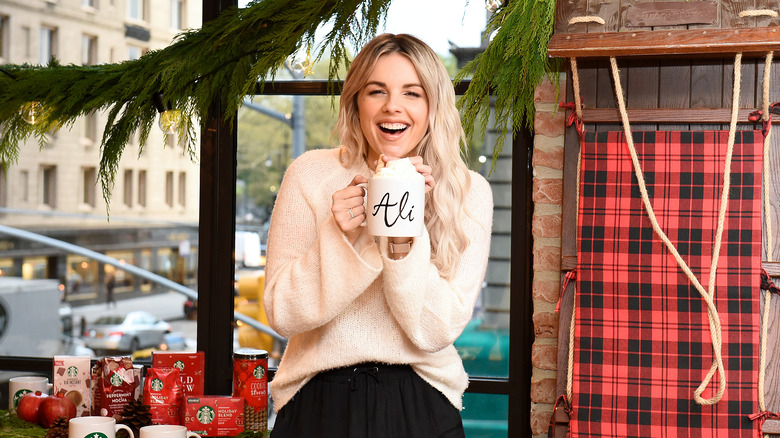 Ali Fedotowsky-Manno on set holding mug