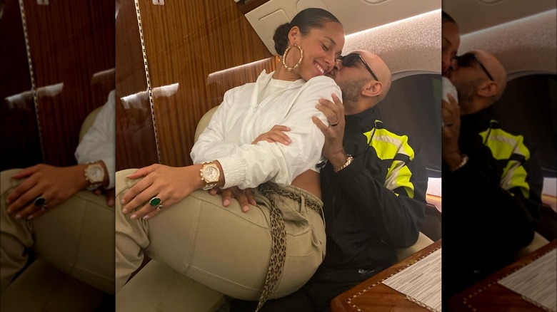 Alicia Keys in Swizz's lap, kissing cheek