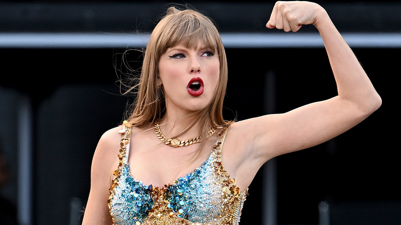 Taylor Swift flexing arm, looking to the left 