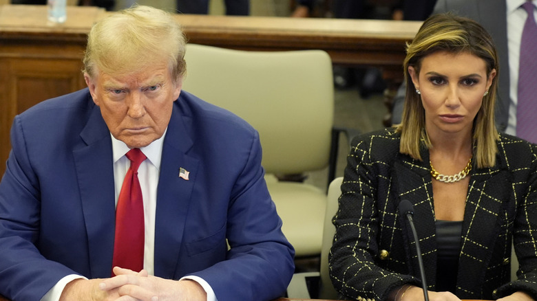 Donald Trump and Alina Habba looking seriou sitting next to each other in court