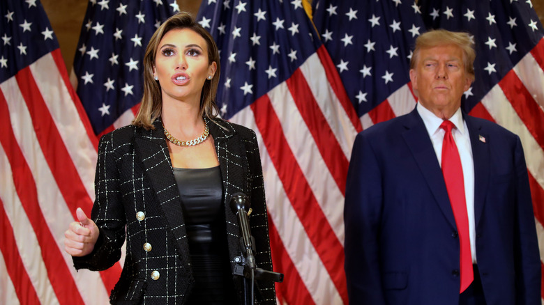 Alina Habba speaking at an event while Donald Trump watches