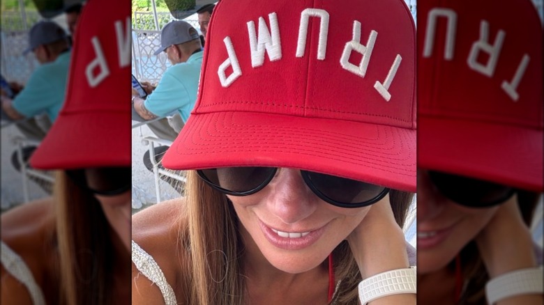 Alina Habba wearing red hat with "Trump" written upside down on it