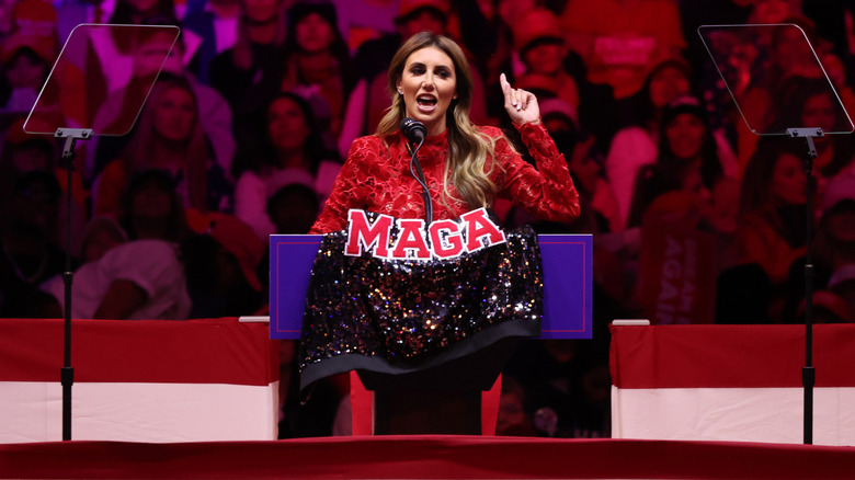 Alina Habba speaking at podium with MAGA sign