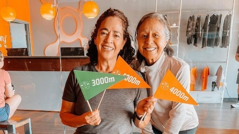 Two women holding flags at Orangetheory