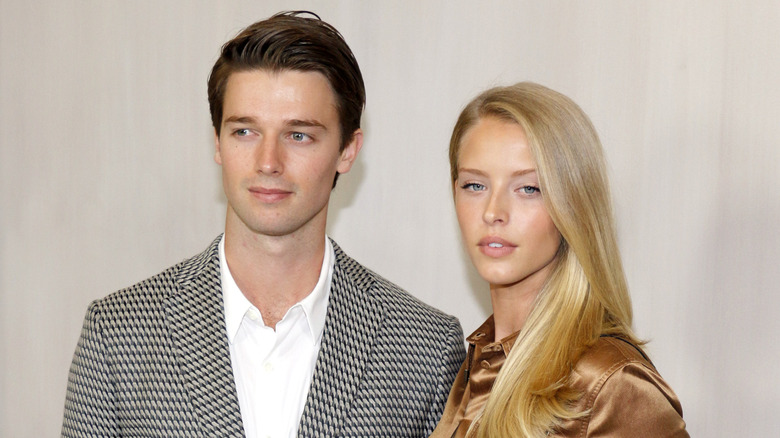 Abby Champion and  Patrick Schwarzenegger posing at a red carpet event