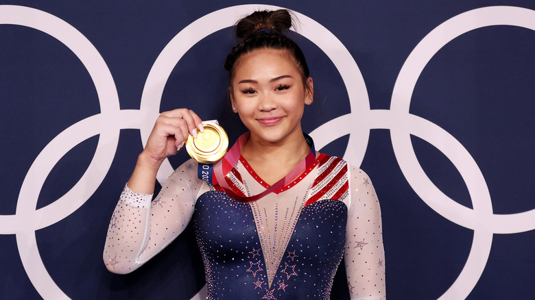 Suni Lee poses after winning gold at the 2020 Olympic Games