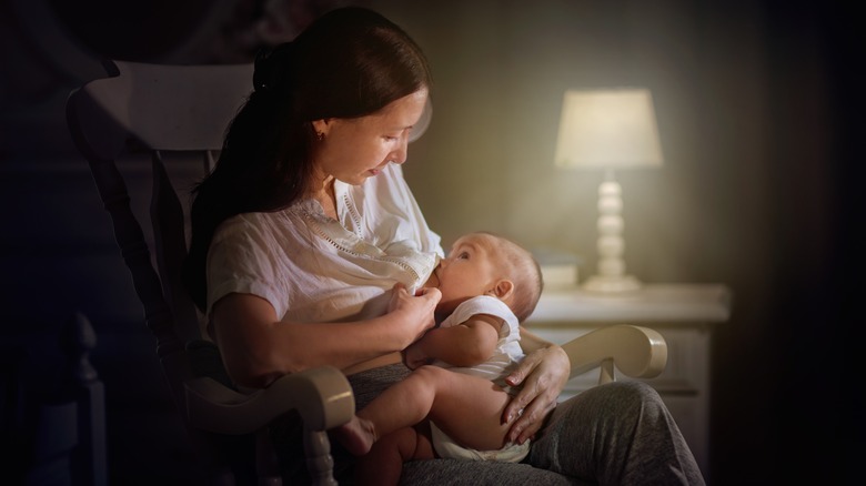 A mom breastfeeding her baby at night in a bedroom