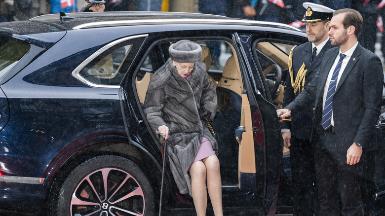 Queen Margrethe getting out of car with walking stick