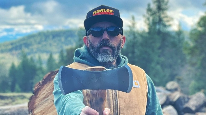 Josh Lazie Resnik in sunglasses holding an axe