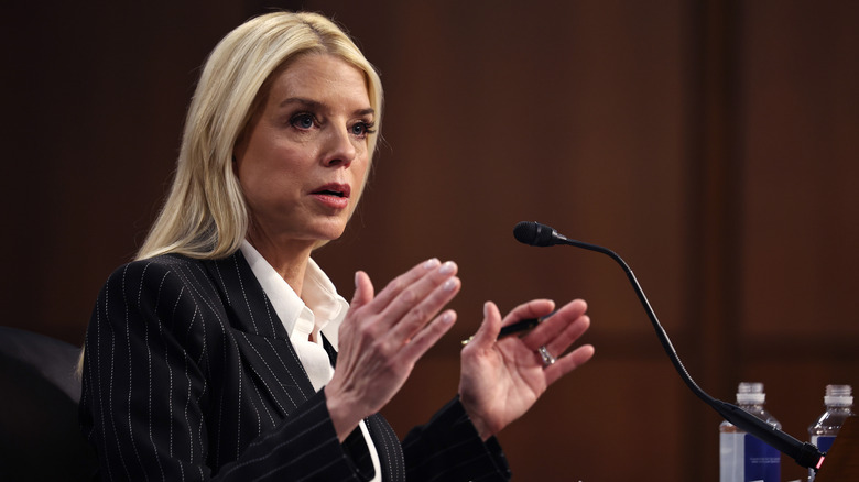 Pam Bondi looking serious and gesturing with her hands