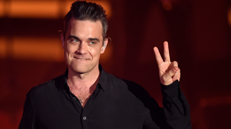 Robbie Williams making the peace sign