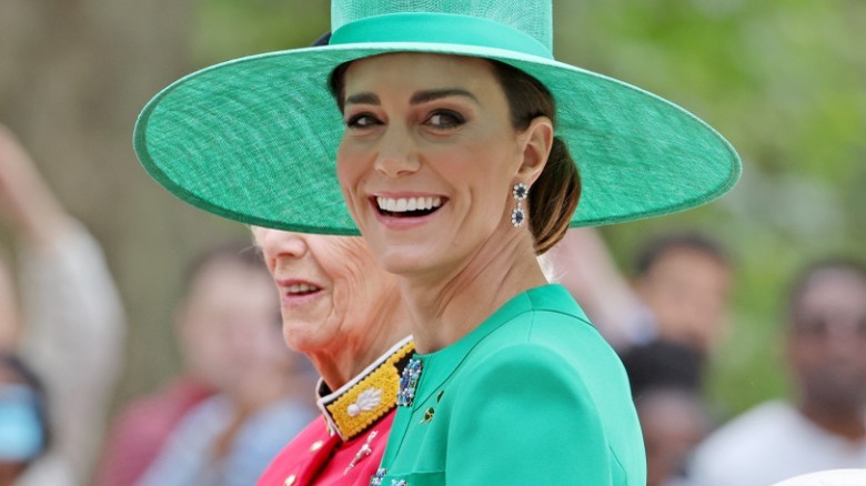 Kate Middleton smiles in a green hat and dress 