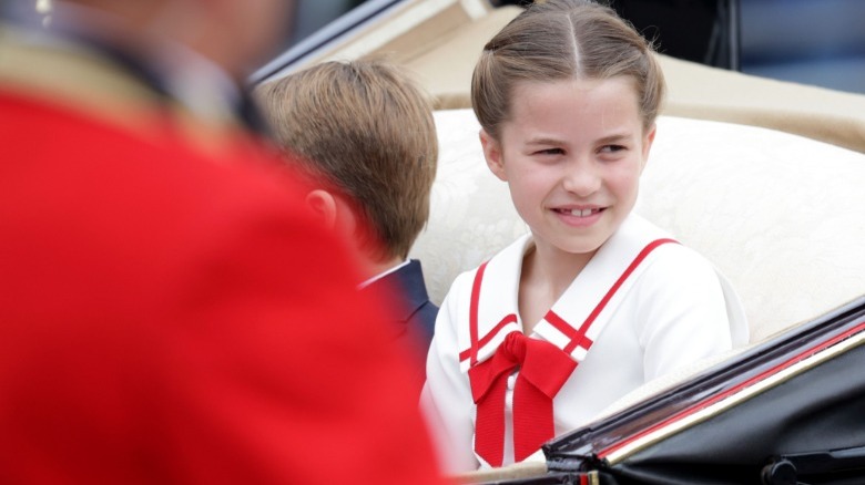 Princess Charlotte smiles in a red and white dress