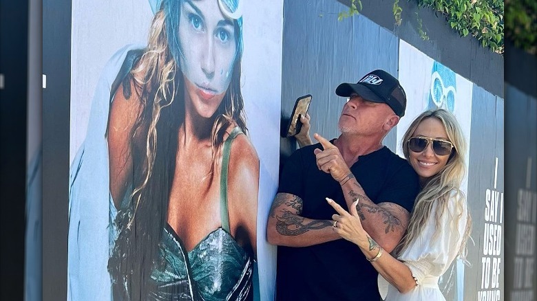 Tish Cyrus and Dominic Purcell posing with a poster