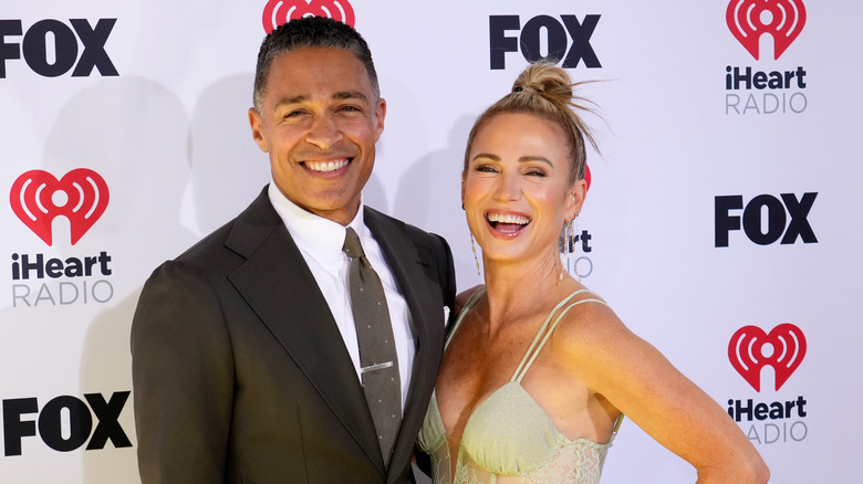 T.J. Holmes and Amy Robach smiling and posing 