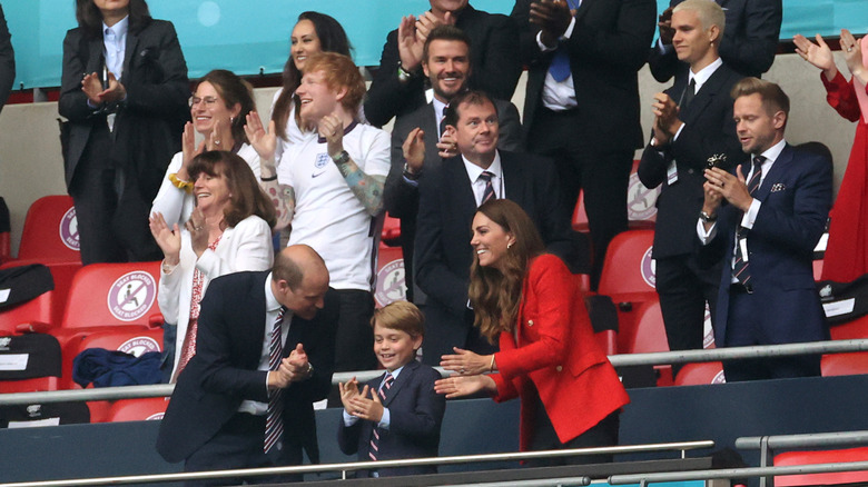 Prince George, Prince William, Princess Catherine and David Beckham at an event 