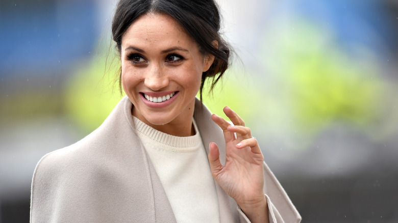 Meghan Markle smiling and waving