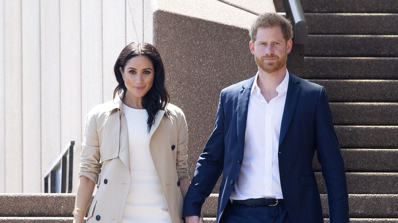 Meghan Markle and Prince Harry holding hands on steps