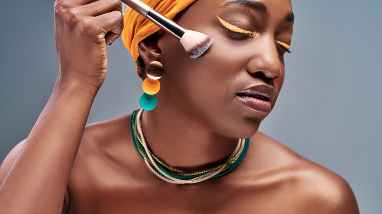 Woman applying makeup with brush