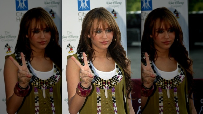 Miley Cyrus holding a peace sign 