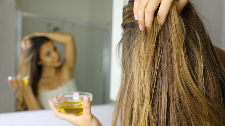 A woman applying hair oil