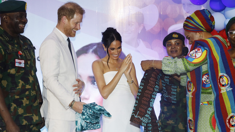 Prince Harry and Meghan Markle accepting gifts in Nigeria