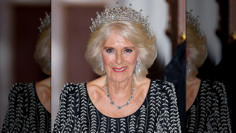 Camilla smiling and wearing the Girls of Great Britain and Ireland tiara