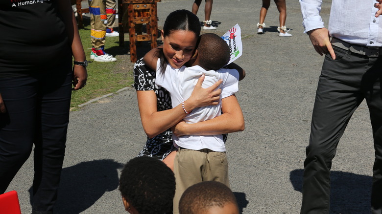 Meghan Markle hugging a child