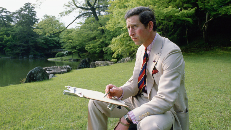 King Charles sketching outside in park