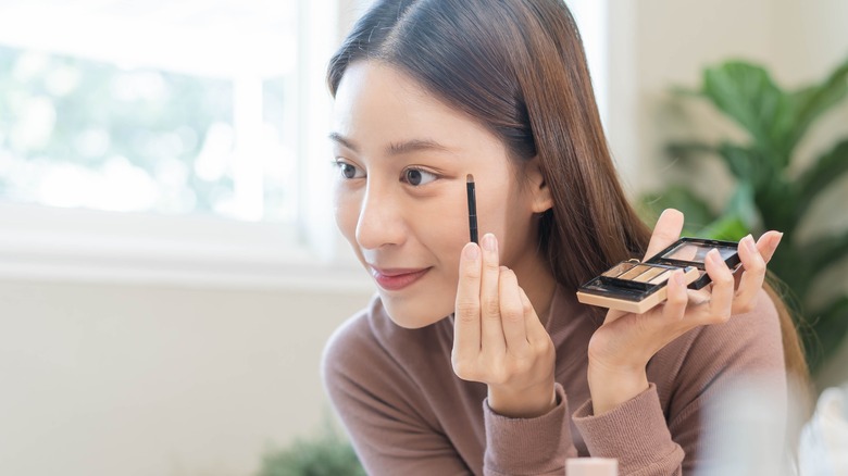 Woman applying eyeshadow