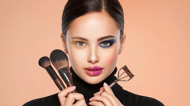 Woman holding makeup brushes