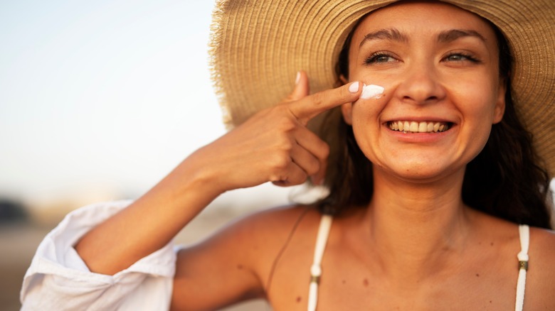 woman putting on sunscreen