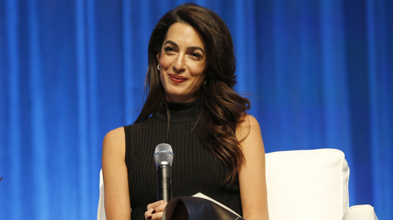 Amal Clooney smiling with mic