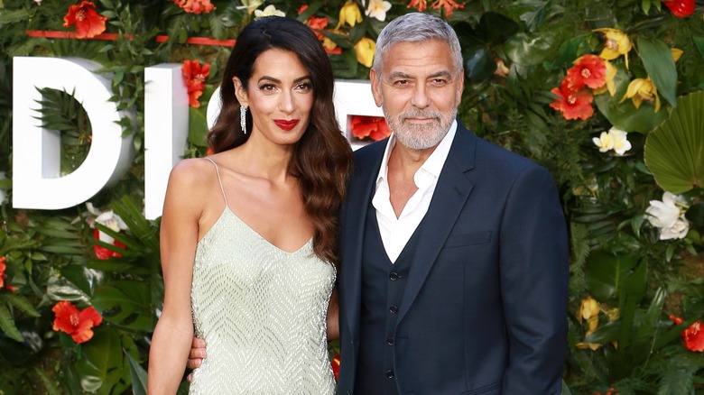 Amal Clooney smiling and George Clooney looking serious